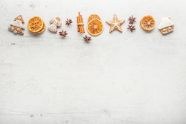 Cinnamon star anise gingerbread and dry orange on white concrete background. Top of view.