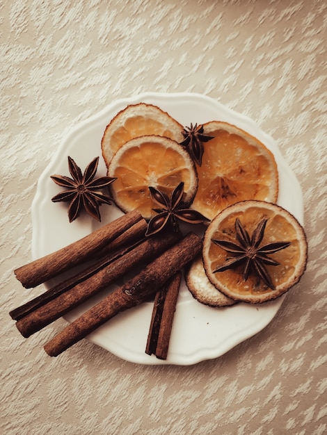 Cinnamon and star anise with orange on a saucer with a fashionable tint