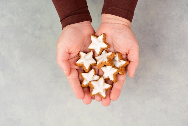 Cinnamon stars Zimtsterne traditional german christmas cookies in the hands gingerbread with anise