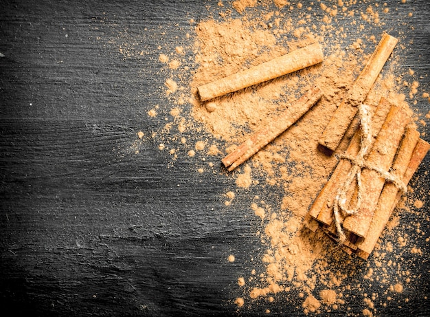 Cinnamon sticks. On a black wooden table.