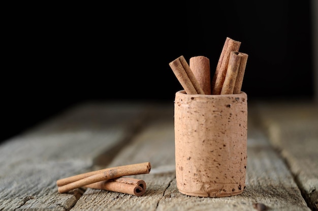 Cinnamon sticks on dark wood table Shallow depth of field A lot of copy space