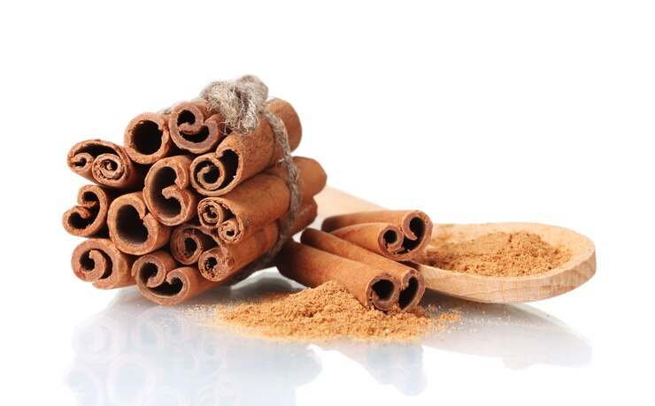 Photo cinnamon sticks and powder in wooden spoon isolated 