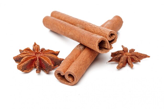 Cinnamon sticks and star anises on white surface