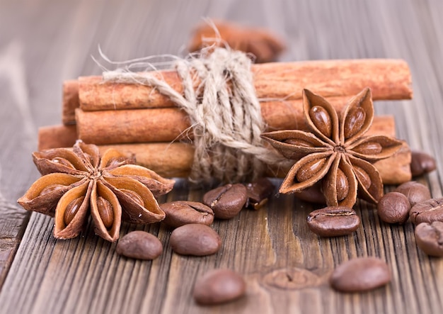 Cinnamon sticks tied with twine coffee and star anise on the old wood