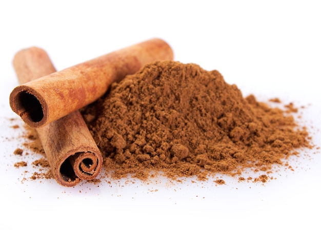 Cinnamon sticks with powder isolated on white background