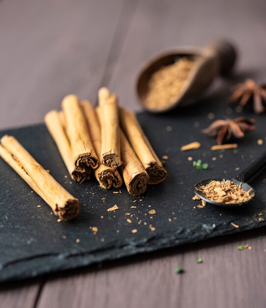 Cinnamon stisk and powder on the wood brown table anise stars rustic close up spicy