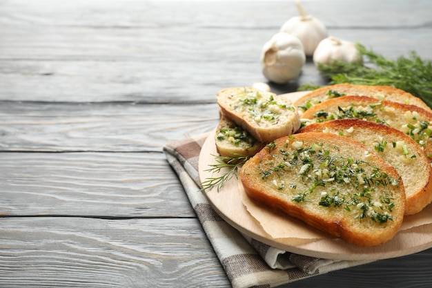 Circle board with toasted garlic bread on wooden, close up