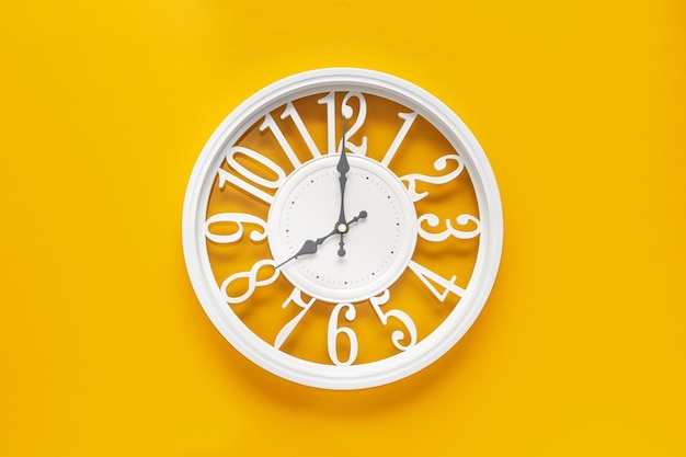 Circle clock on yellow background wall