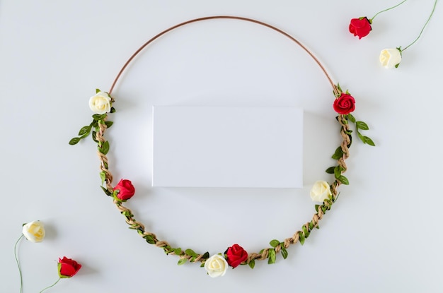 Cornice circolare di fiori rose rosse e bianche con foglie su sfondo bianco