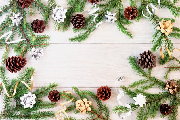 Circle frame made of fir branches, gold and silver ribbons and cones