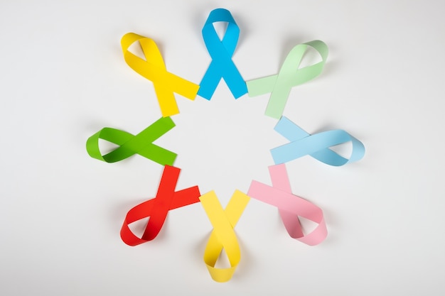 circle of multi color awareness ribbons on white background top view.