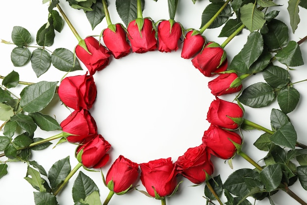Круг красных роз на белом столе