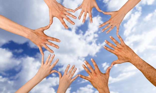 Foto mani a forma di cerchio della squadra sullo sfondo del cielo. concetto di unità, fiducia, lavoro di squadra e insieme.