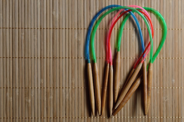 Circular bamboo knitting needles on a wooden surface.