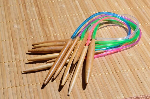 Circular bamboo knitting needles on a wooden surface.