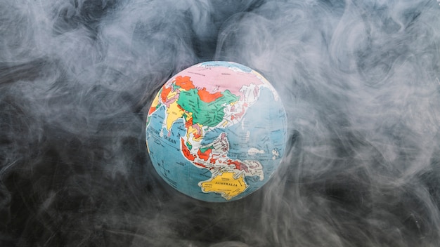 Photo circular globe surrounded by smoke