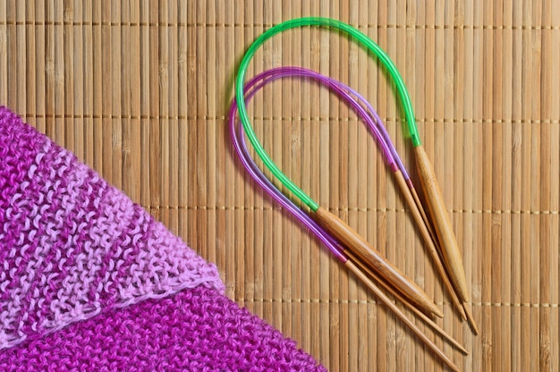 Circular knitting needles lie next to the beaches.