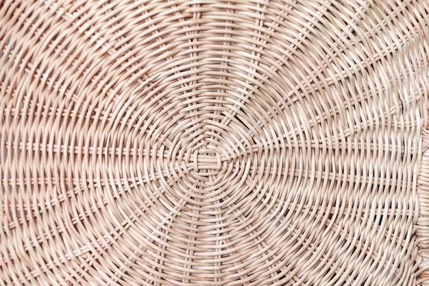 Circular weave rattan pattern round rattan furniture background
light brown texture weave rattan texture and background a fragment
of a basket made of willow twigs or garden furniture texture