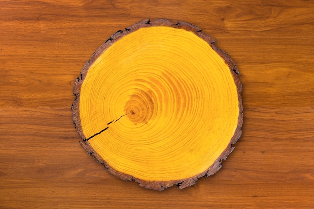 Circular wooden cut tree cutting kitchen Board, isolated on wooden table