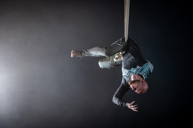 Artista di circo sulle cinghie aeree con costume