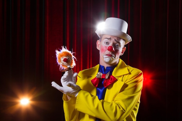 Circusclown speelt nummer A man in clownskostuum met speeltje