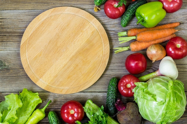 Cirkel snijplank en groenten op houten achtergrond gezond eten