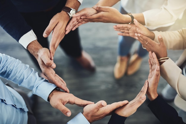 Cirkel van handen teamwork en saamhorigheid met een groep zakelijke collega's die in een team staan van bovenaf Samenwerken om eenheid te tonen en steun te geven in een vergadering voor motivatie