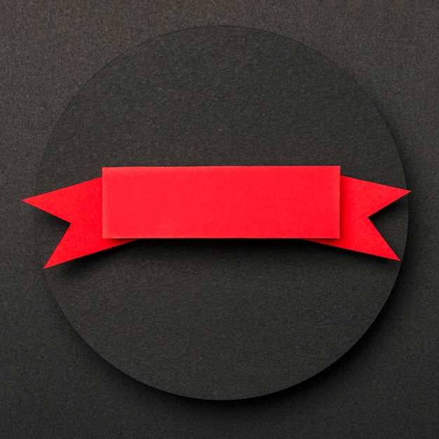 Cirkelvormige geometrische vorm van zwart papier en rood lint