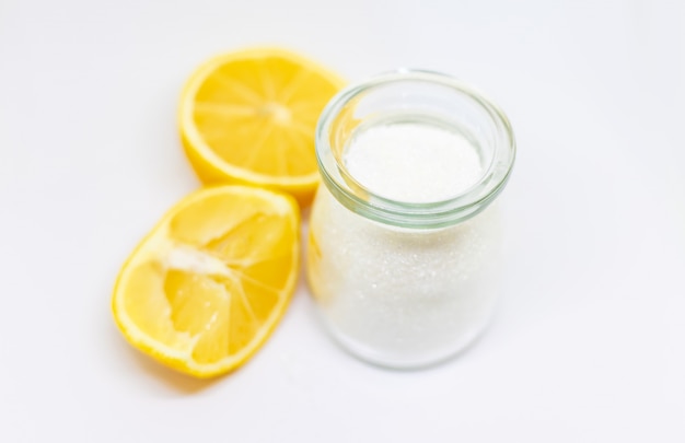 Citric acid in a glass jar and lemons