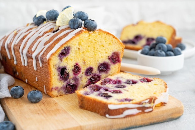 Citroen-bosbessencake met citroenglazuur en verse bessen bovenop op het bord Ruimte kopiëren