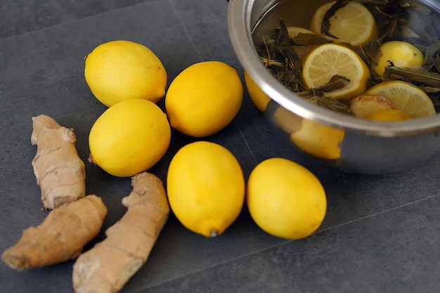 Citroen en gember samen koken in een pot en citroen- en gembersap drinken bij griep en verkoudheid