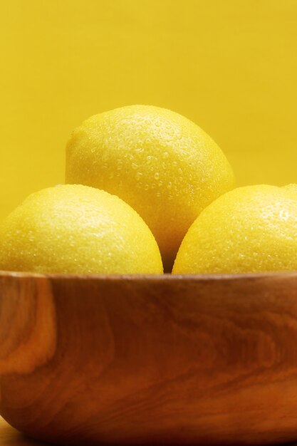 citroen in de houten tafel en gele achtergrond
