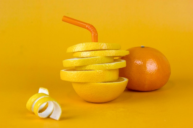 Citroenfruitschijfje in lagen met schillen en sappige sinaasappel geïsoleerd op gele achtergrond Sappige citroen