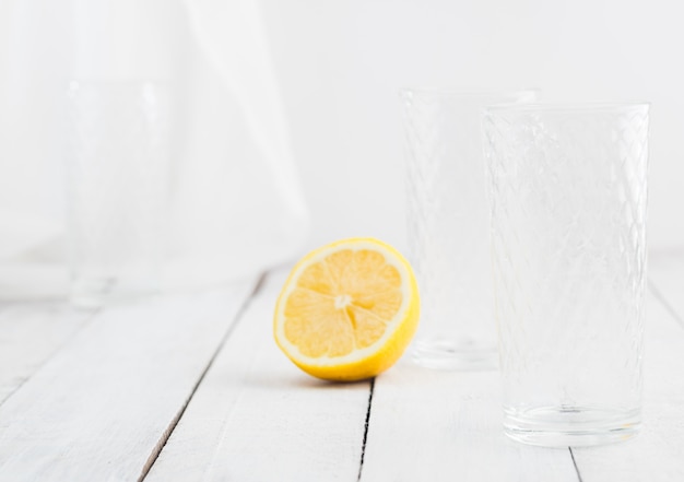 Citroensap detox water. Mineraalwater doordrenkt met citroenen. Houten witte tafel.