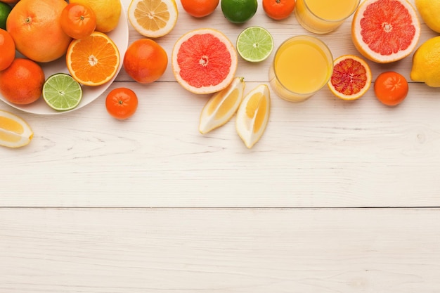 Citrus achtergrond. Sinaasappelen, citroenen, grapefruits en ander antioxidant fruit op witte houten planken. Gezonde levensstijl, natuurlijk vitamineconcept, bovenaanzicht, kopieerruimte, blogger plat leggen