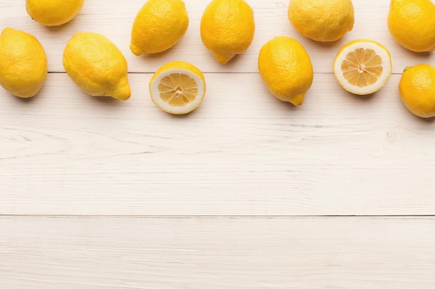 Citrus background. border of lemons on white wooden planks. healthy lifestyle, natural vitamins concept, top view, copy space, flat lay