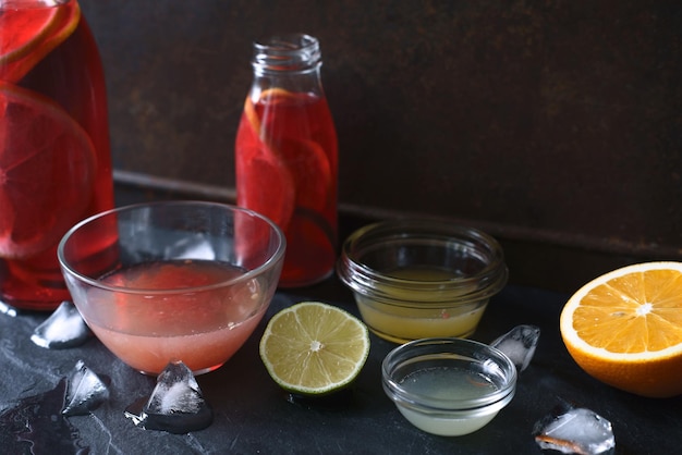 Citrus cocktail in the different glass dish on the dark stone background