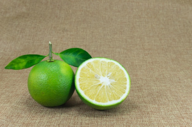 Citrus Fruit Composition with leaves on brown fabric background