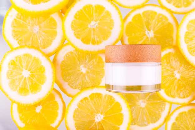 Citrus fruit glass jar of cream moisturizer and orange lemon slices Flat lay top view skin care