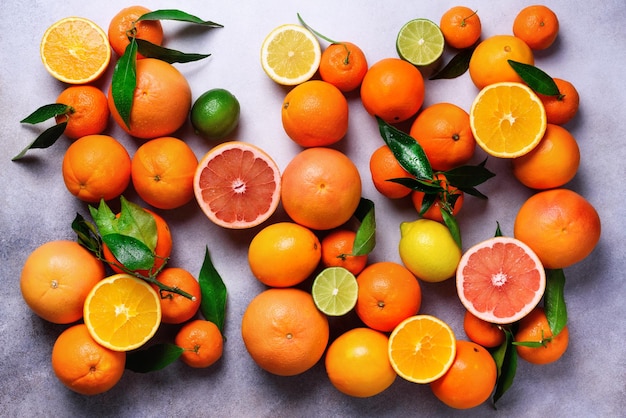 Citrus fruits background Assorted fresh citrus fruits with leaves Orange grapefruit lemon lime tangerine Top view