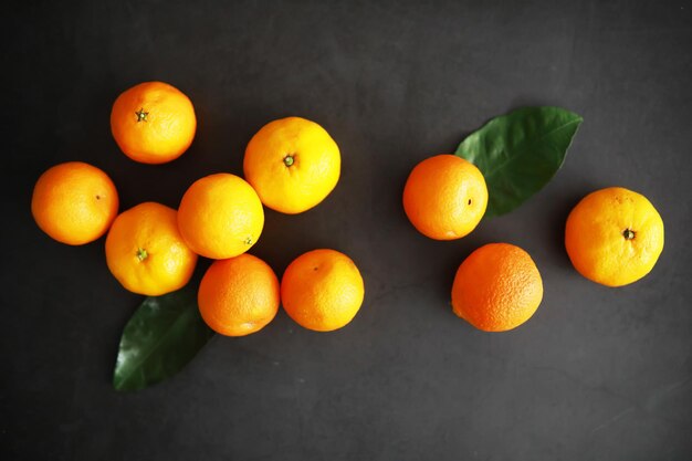 Citrus fruits on a gray background. Tangerines with leaves. Christmas fruit.