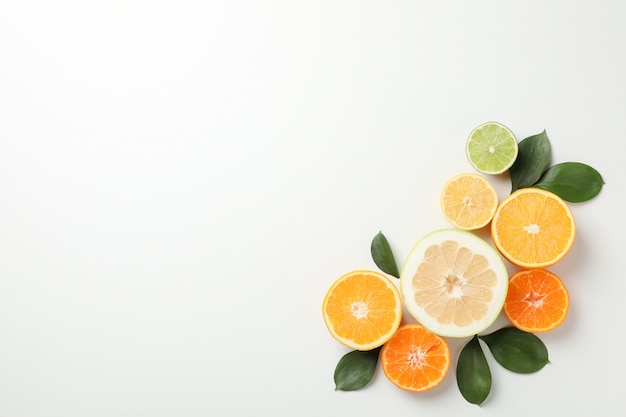 Citrus fruits and leaves on white background, space for text