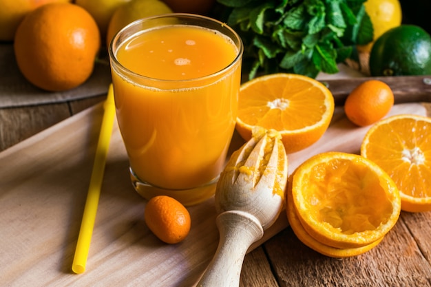 柑橘系の果物オレンジレモンライム、フレッシュミント、リーマー、ガラスのジュース