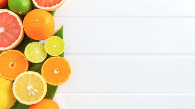 Citrus fruits on white wooden background.