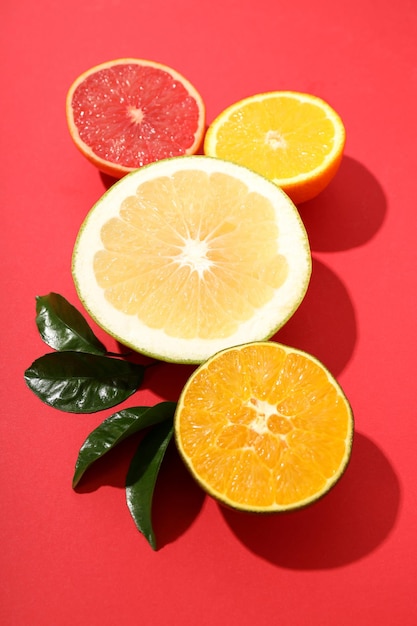 Citrus fruits with leaves on red background