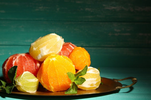 Citrus fruits without skin on tray, on wooden surface