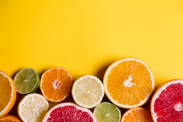 Citrus fuits grapefruit lemon lime orange on a yellow background