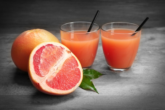 Photo citrus juice and fresh fruits on a wooden table