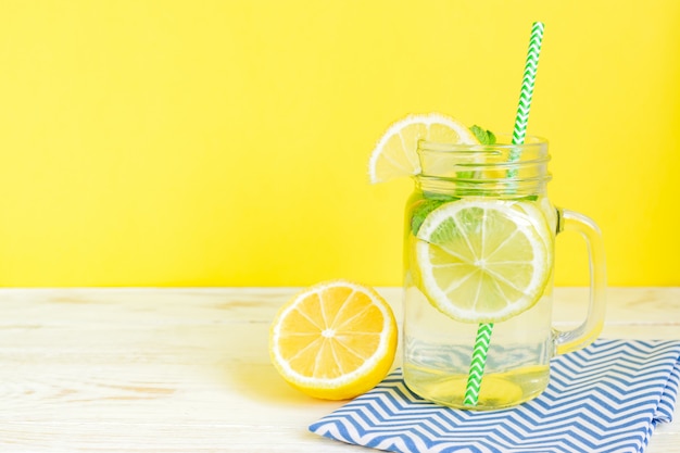 Acqua di limonata agli agrumi con limone affettato e foglie di menta, bevanda salutare e disintossicante in estate