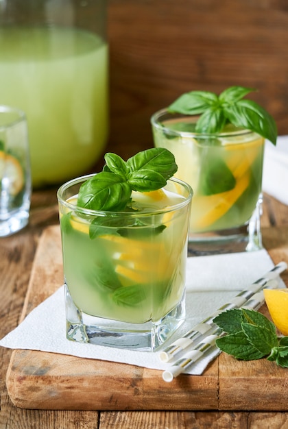 Citrus lemonade with basil and mint on a wooden background